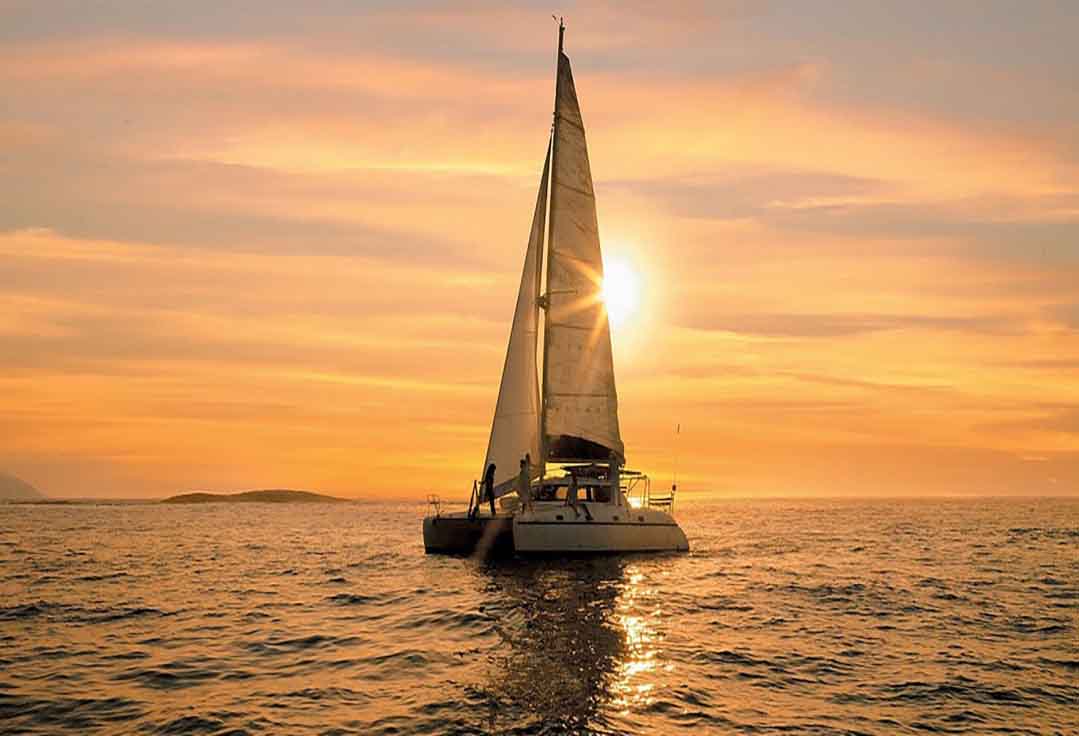 a Key West snorkeling catamaran sails into the sunset.