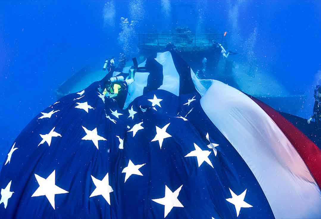 an American flag on the USNS Vandenberg waivers in the current with Key West Scuba Diving.