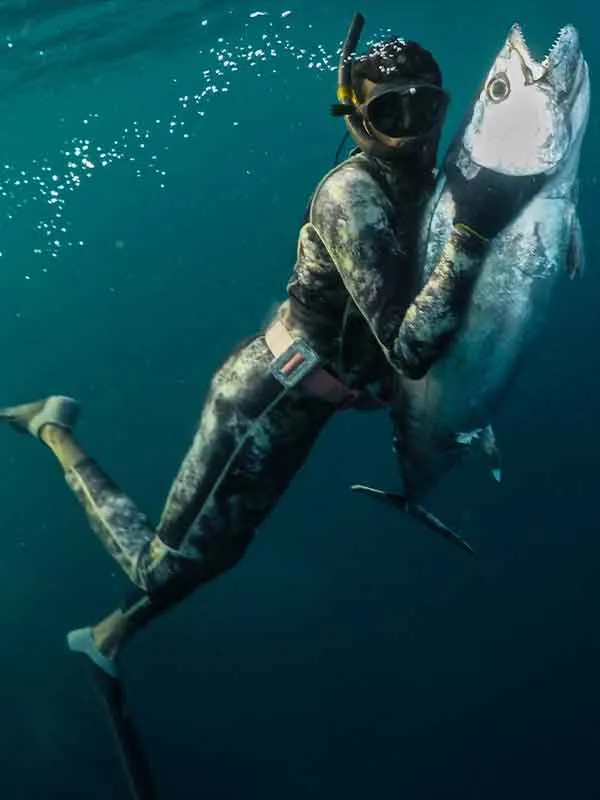 man swims to surface with key west spearfishing